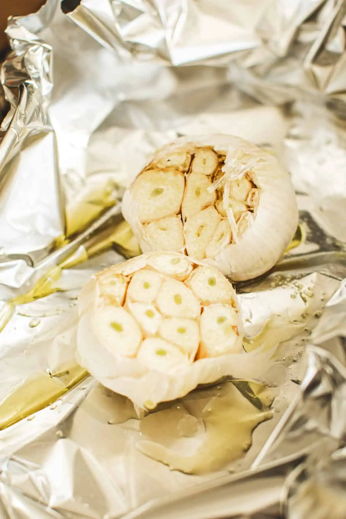 Garlic heads drizzled with olive oil for making Mashed Potatoes with Truffle.