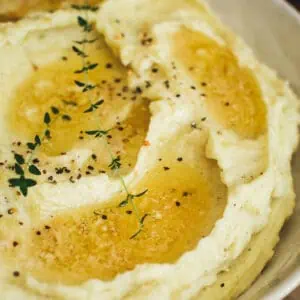 Truffle mashed potatoes in a bowl with extra melted butter on top.