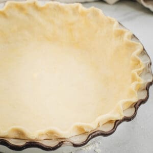 Pie crust with shortening and butter in a pie dish.