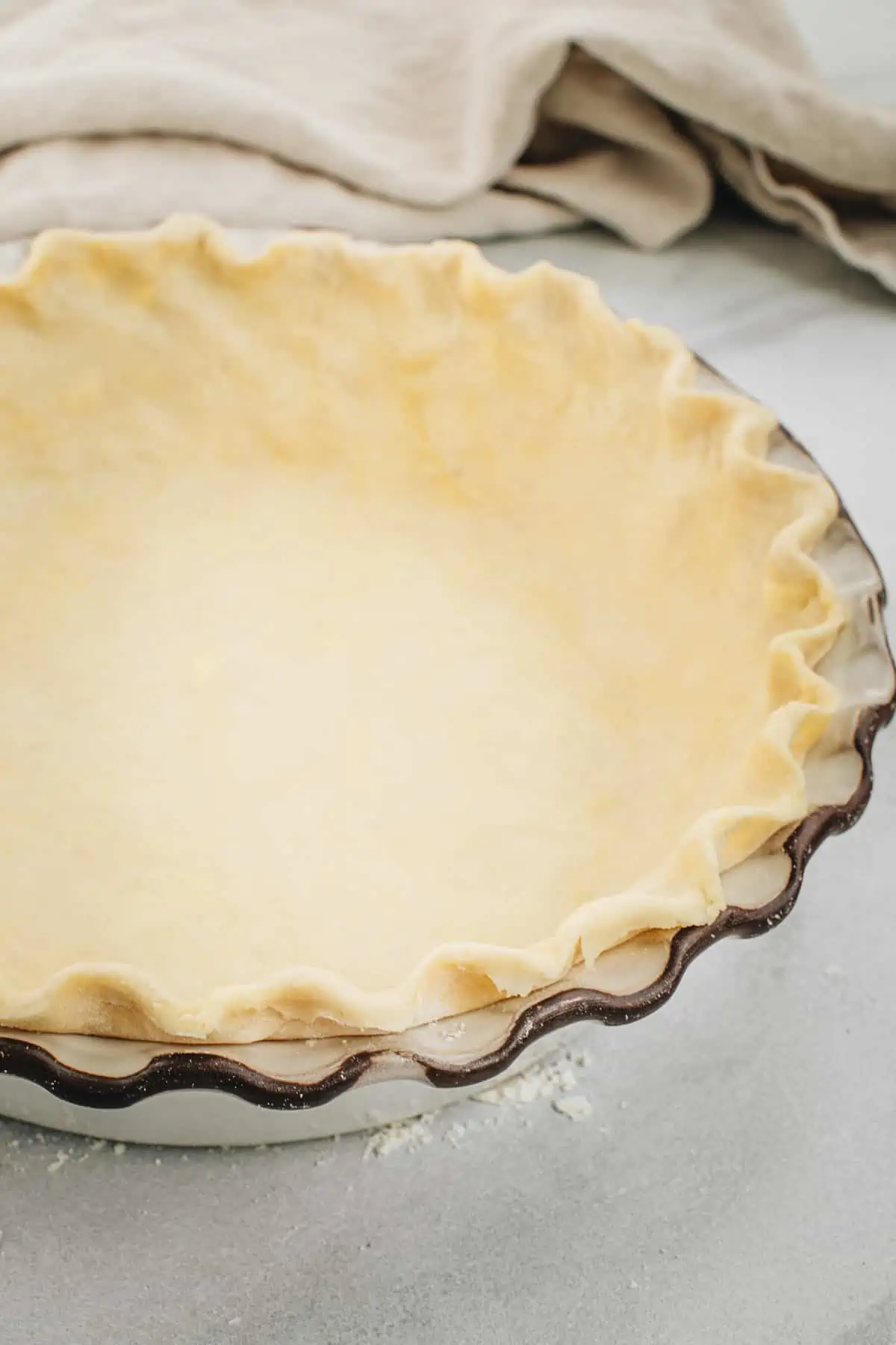 Pie crust with shortening in a pie dish with a fluted edge.