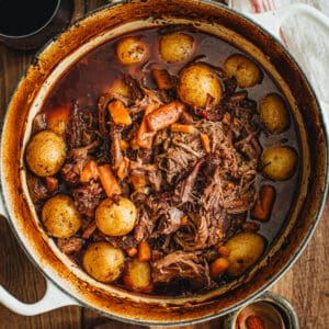 Pot roast in a white Dutch Oven.