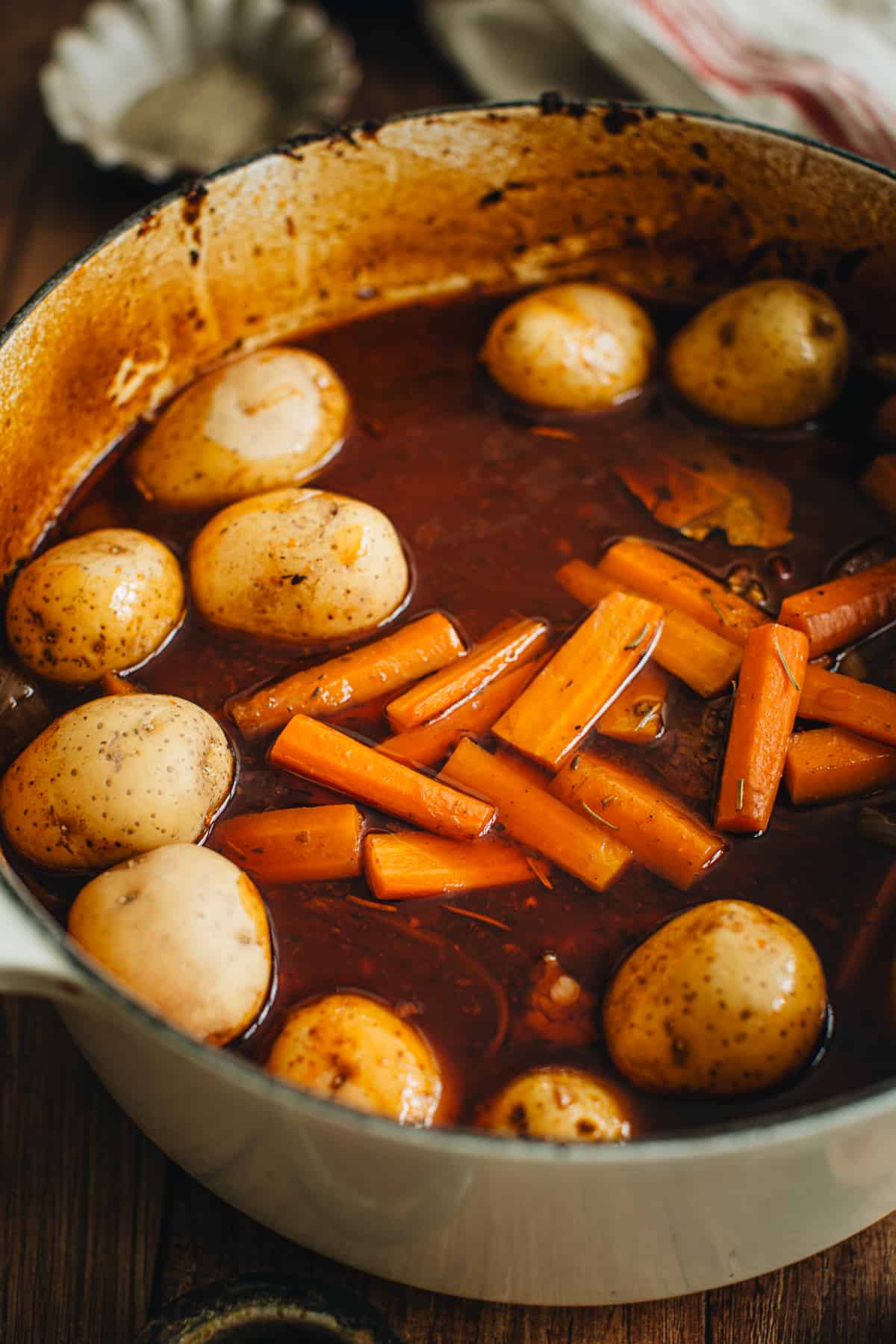 Potatoes added to the pot roast for finishing cooking.