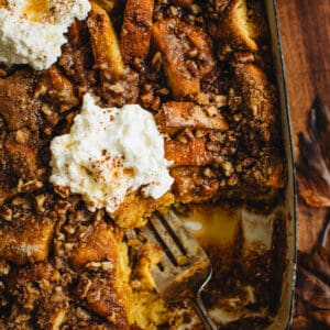 Pumpkin French Toast casserole in a casserole dish with the corner scooped out.