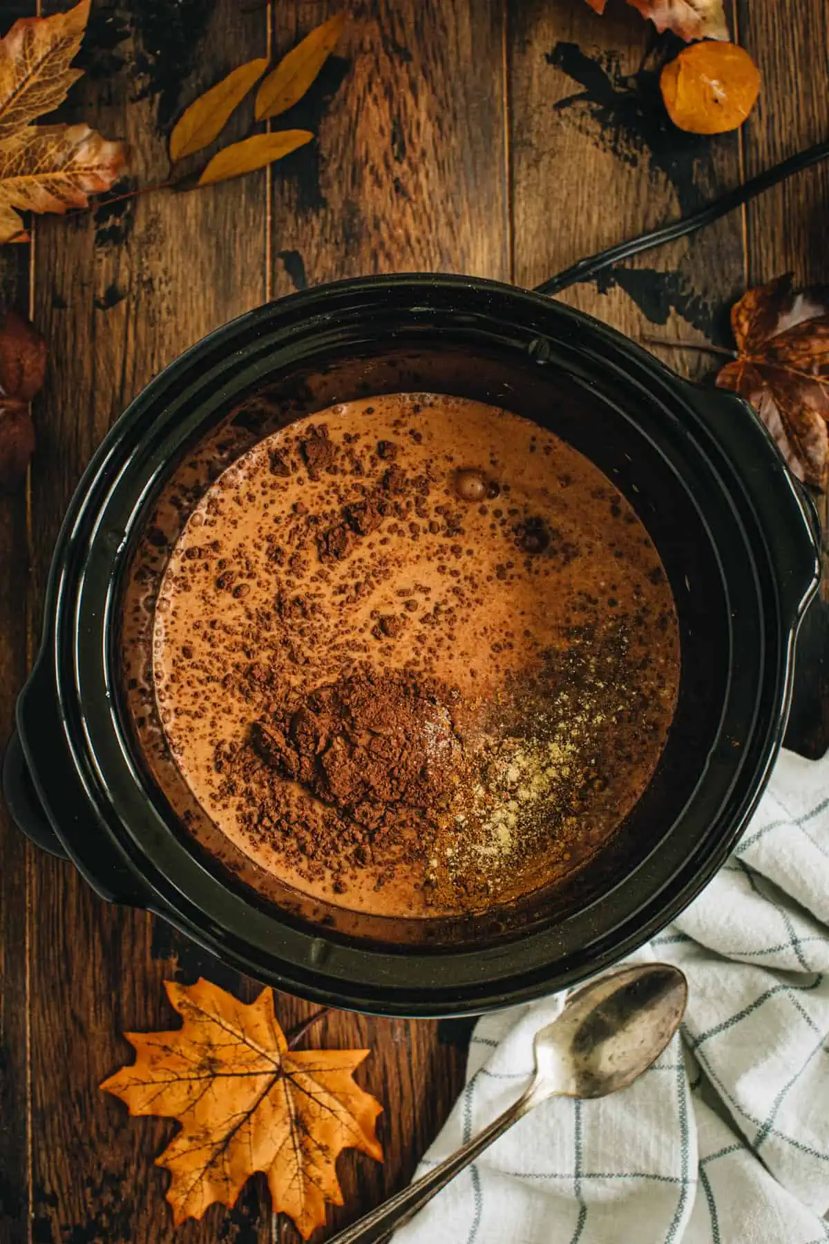 Pumpkin spice hot chocolate ingredients in a slow cooker.