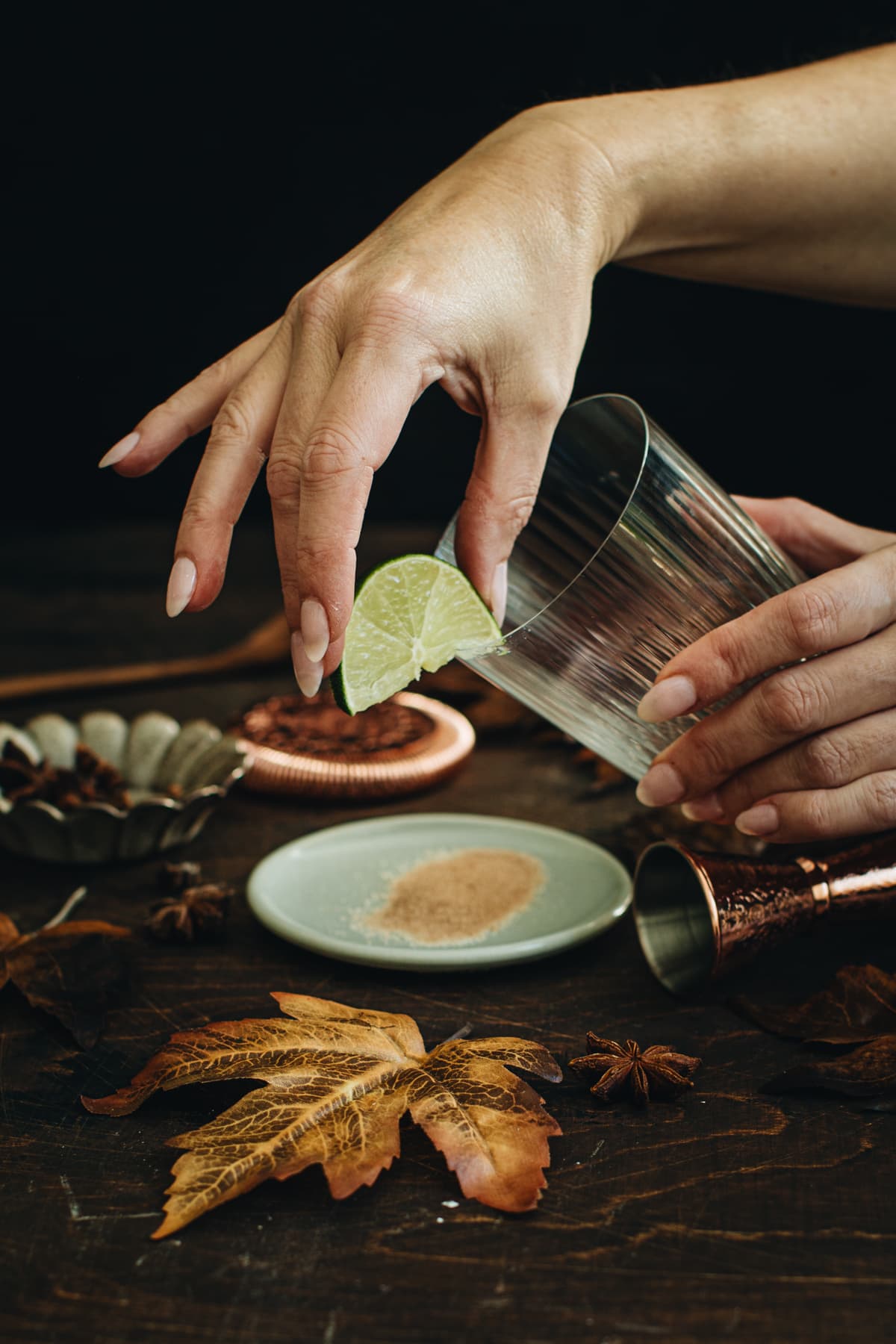 Running a lime wedge along the rim of a glass for making a Pumpkin Spice Margarita.