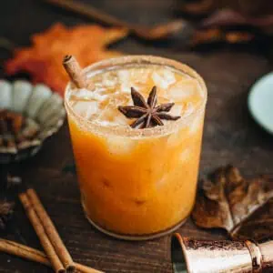 Pumpkin spice margarita with a sugared rim and a cinnamon stick for garnish.