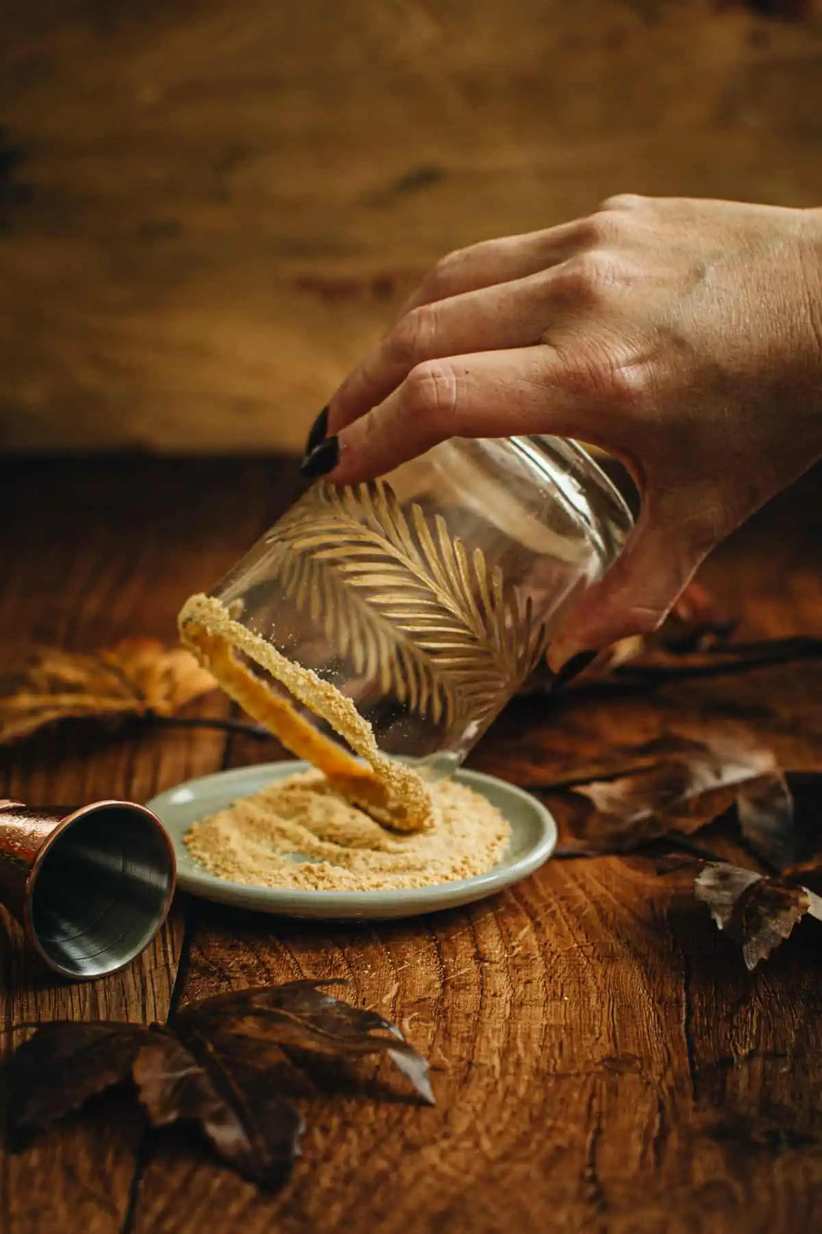 Dipping a glass rim into graham cracker crumbs for making a Pumpkin Spice White Russian.