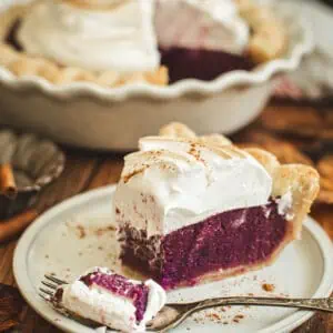 Slice of purple sweet potato pie with a fork scooping out a bite.