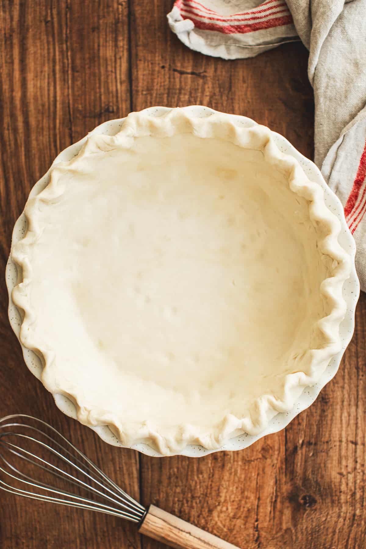 Pie dough in a pie plate with a crimped edge for making purple sweet potato pie.