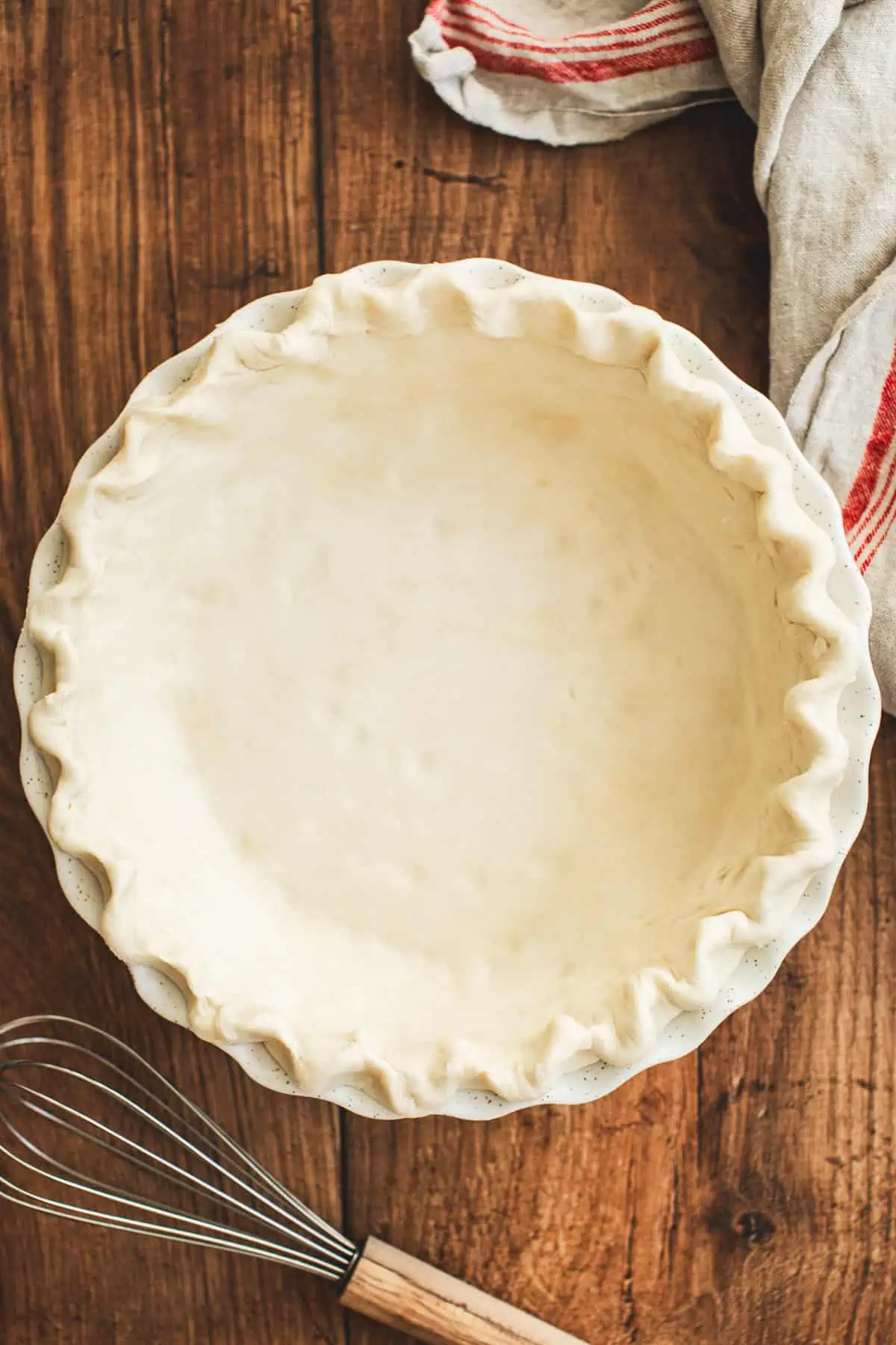 Pie dough in a pie plate with a crimped edge for making purple sweet potato pie.