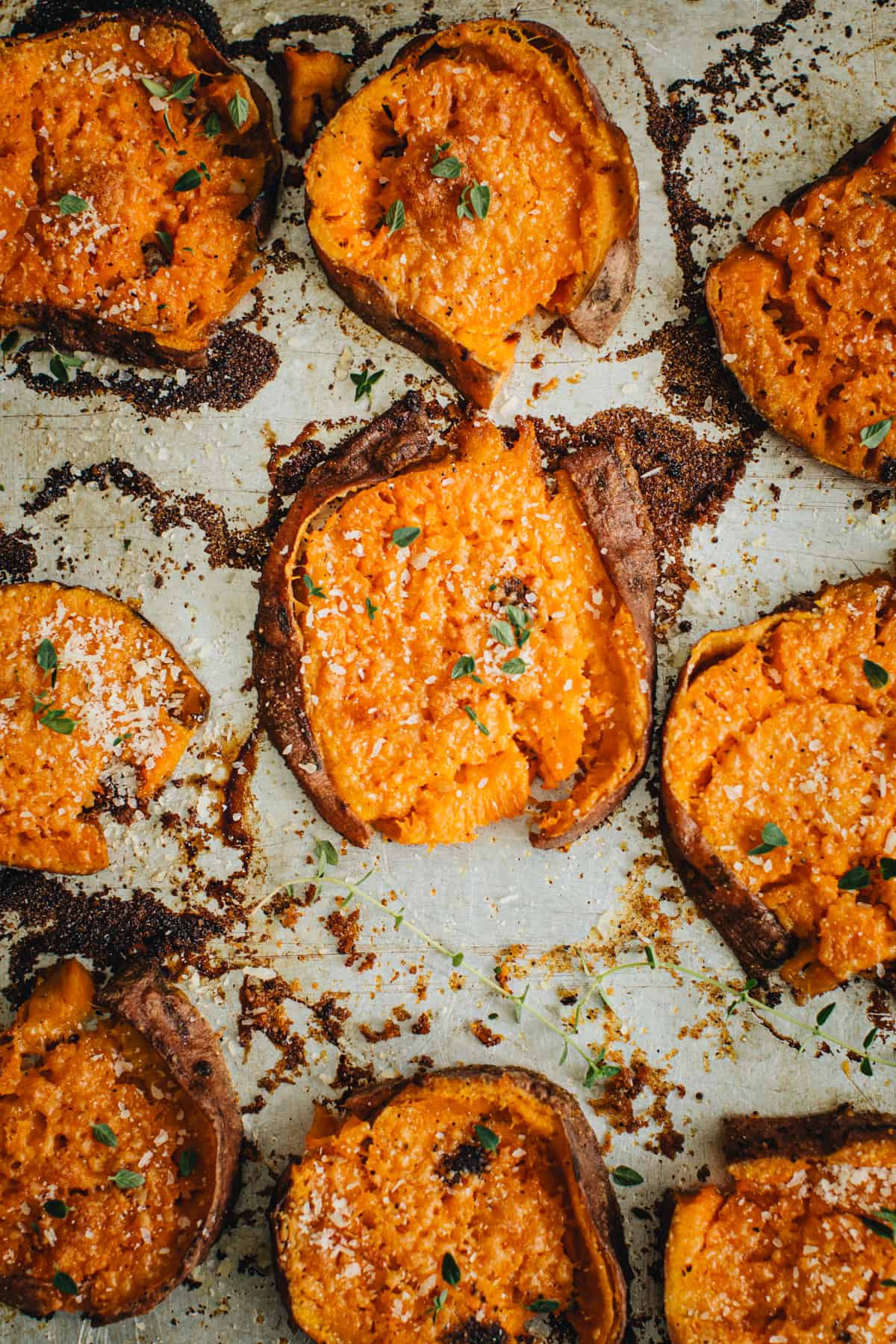 Smashed sweet potatoes topped with fresh thyme.