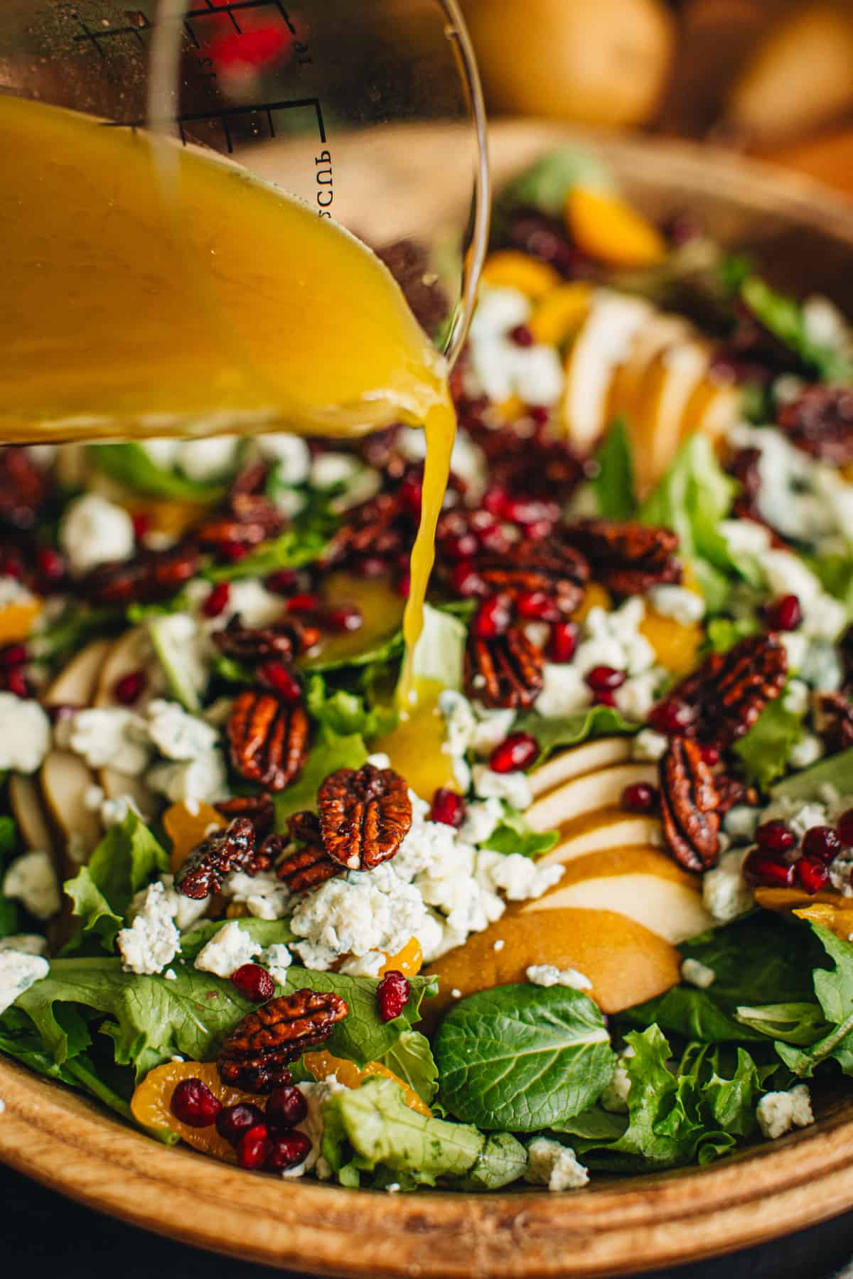 Pouring the homemade vinaigrette dresssing onto Christmas salad.