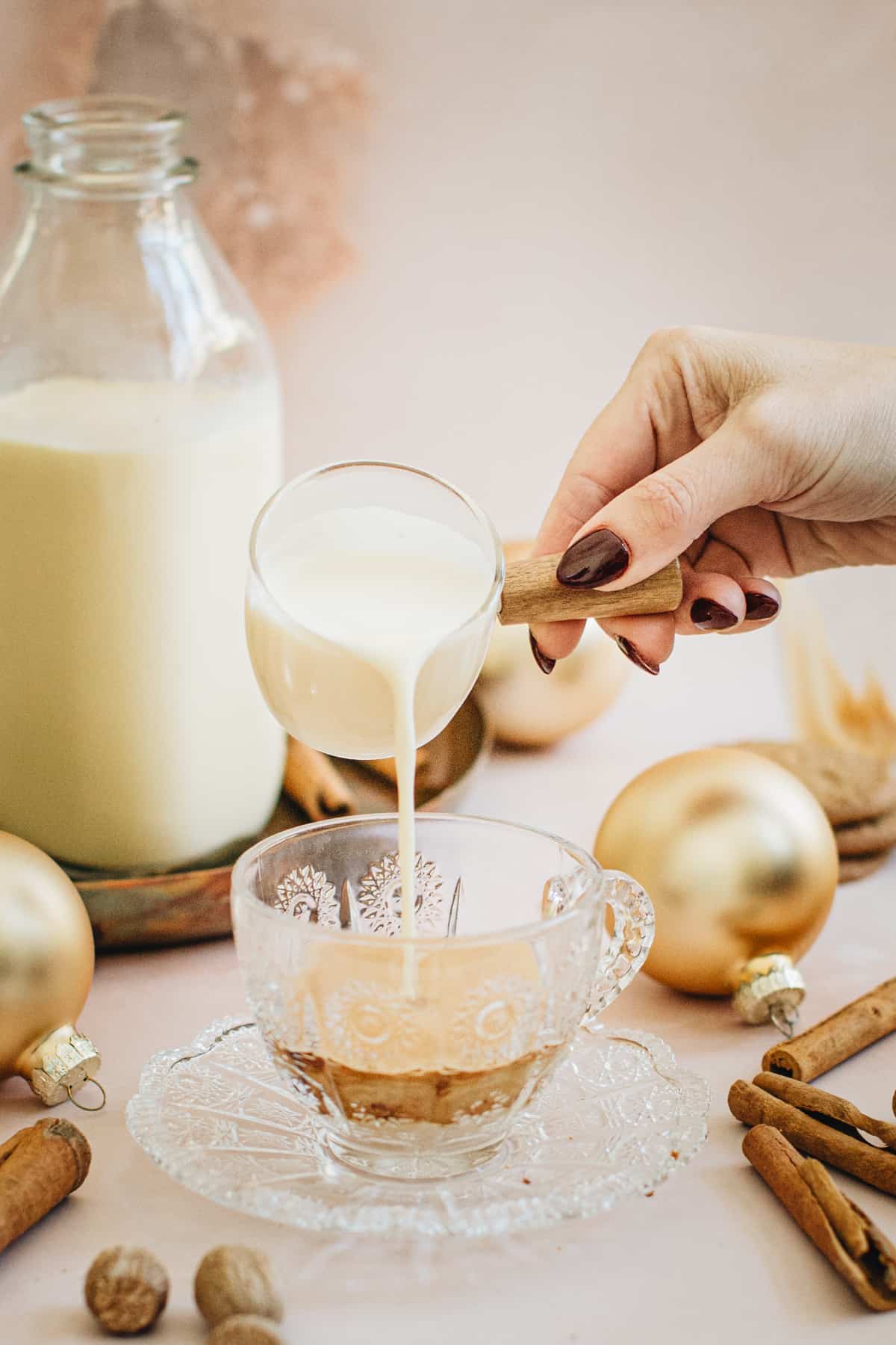 Pouring steamed milk and eggnog over espresso for an Eggnog Latte.