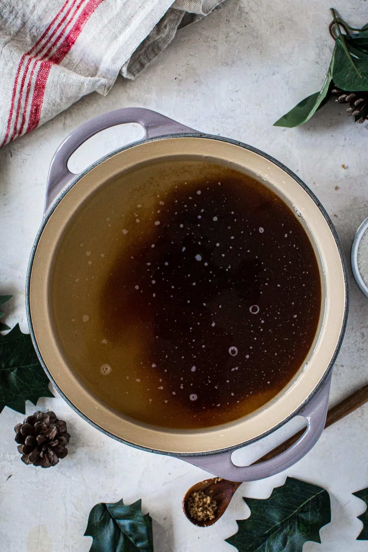 Brown sugar, granulated sugar, and water in a large saucepan for making homemade amaretto.