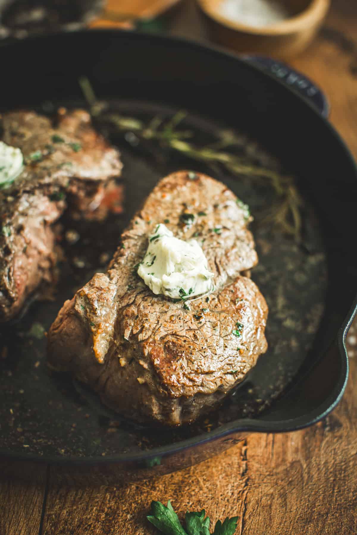 Pan seared filet mignon in a cast iro skillet topped with herb butter.