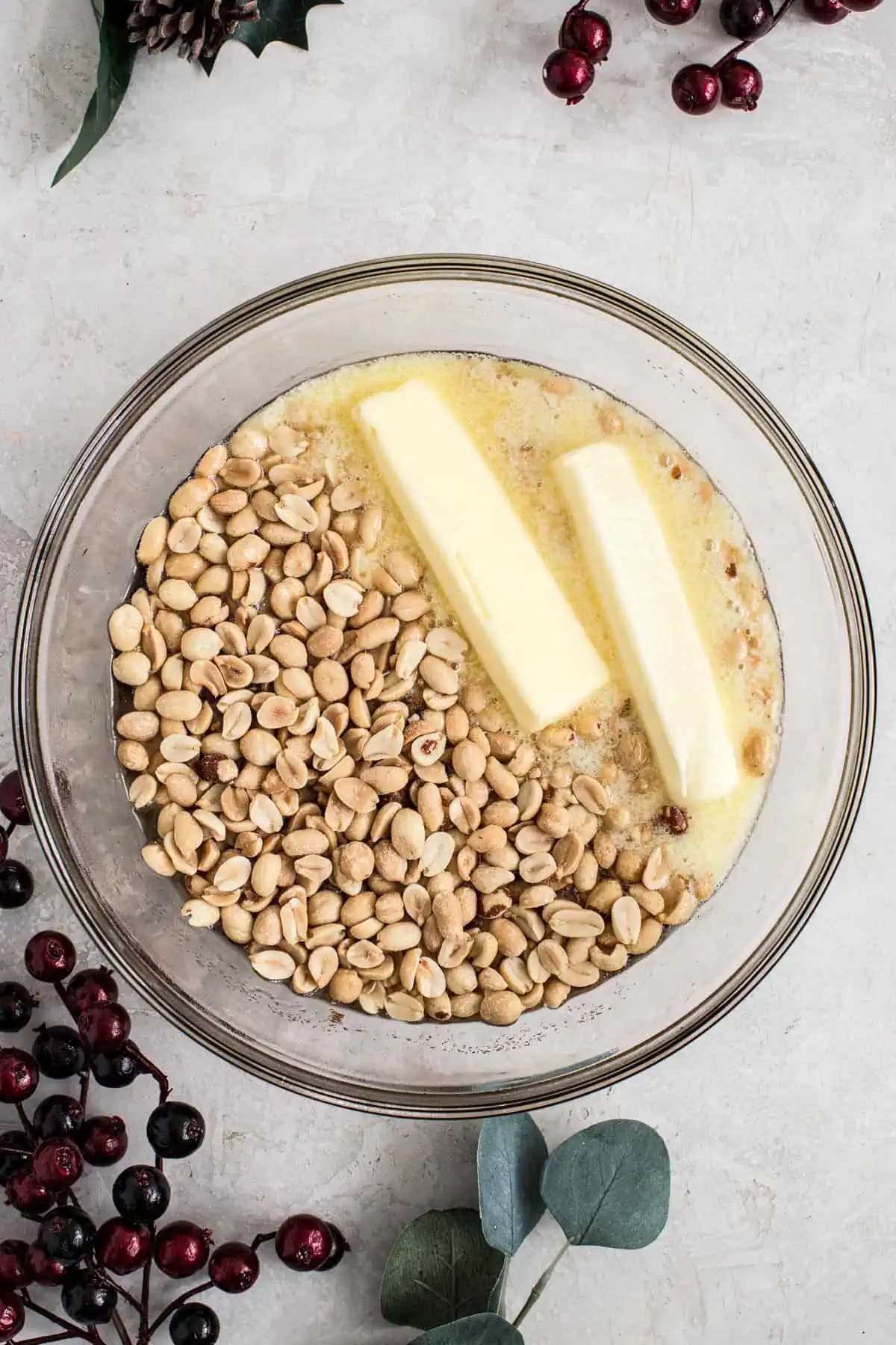 Butter and peanuts added to the heated syrup mixture for making peanut brittle.