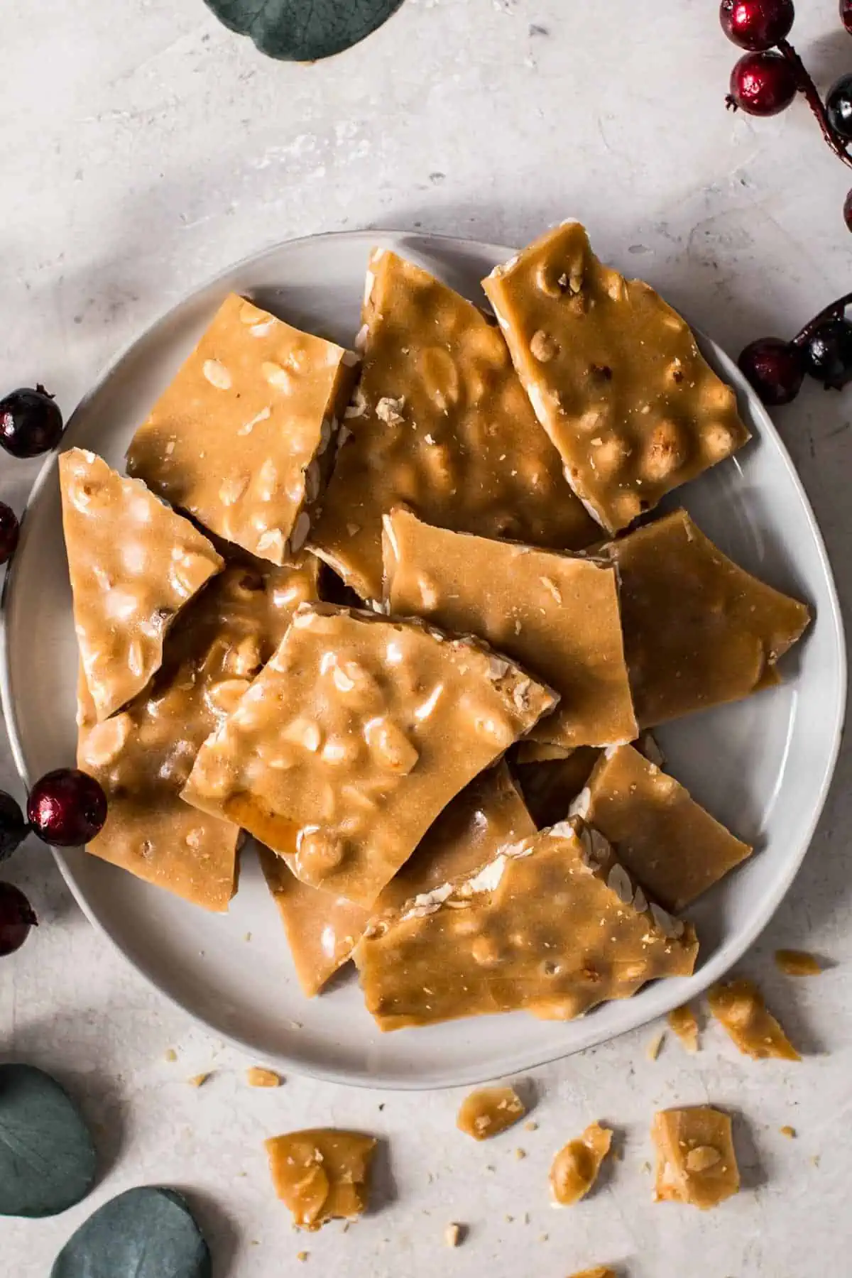 Pieces of microwave peanut brittle on a white plate.