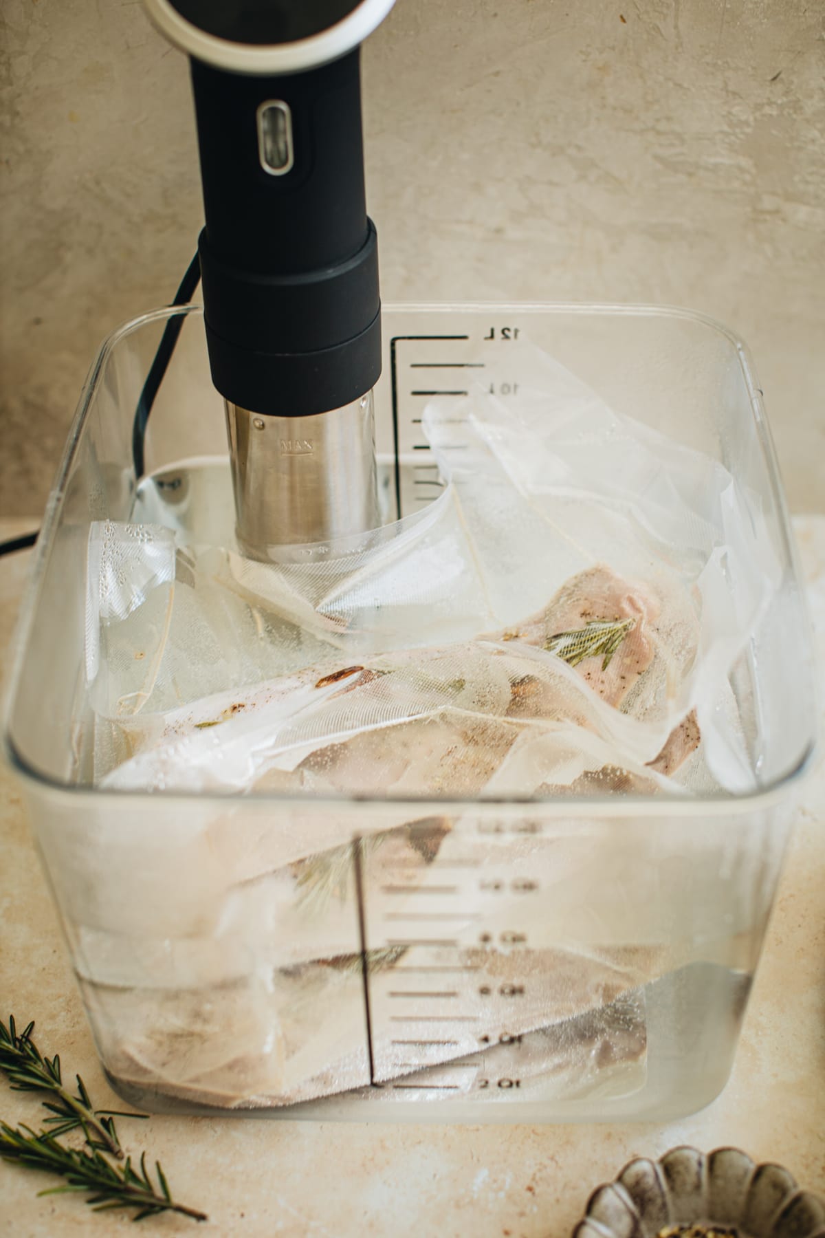 Pork tenderloin in vacuum-sealed bags cooking in a water bath using a sous vide.