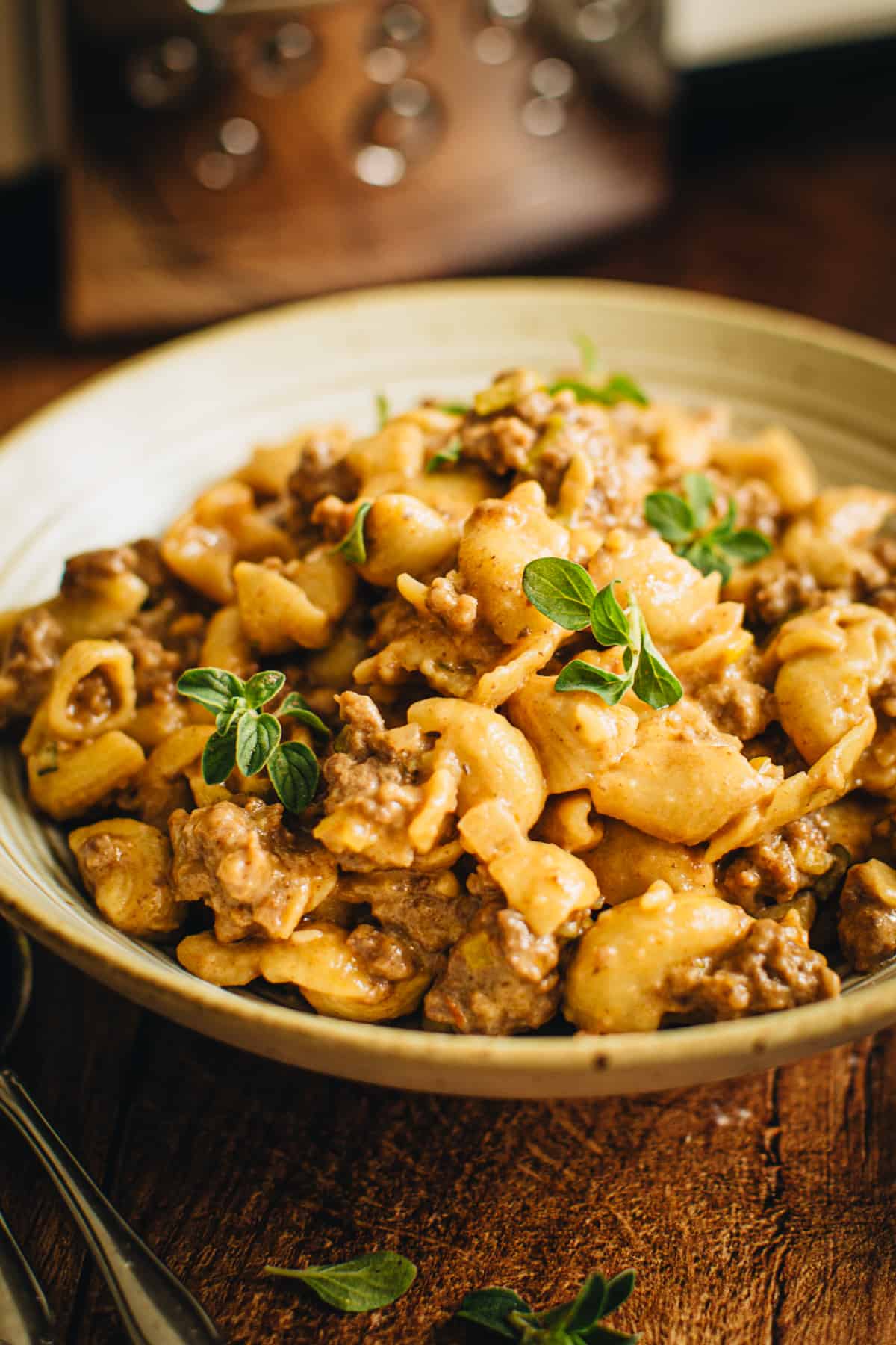 Crockpot hamburger helper in a bowl topped with fresh oregano.