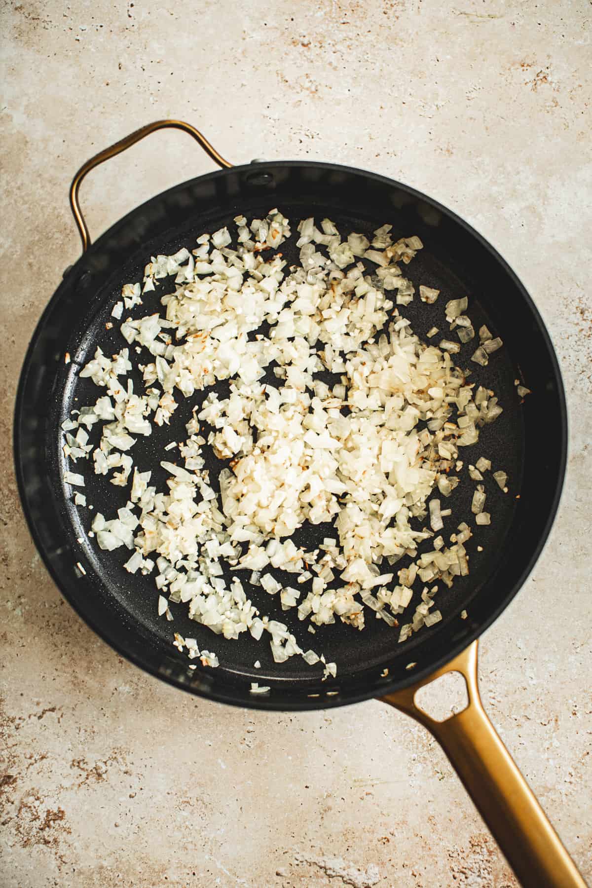 Sautéed onions in a skillet for making Ground Chicken Tacos.