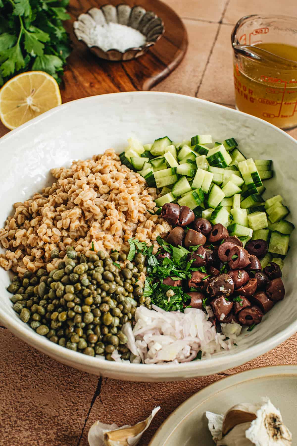 Farro salad ingredients in a large mixing bowl before they are mixed together.